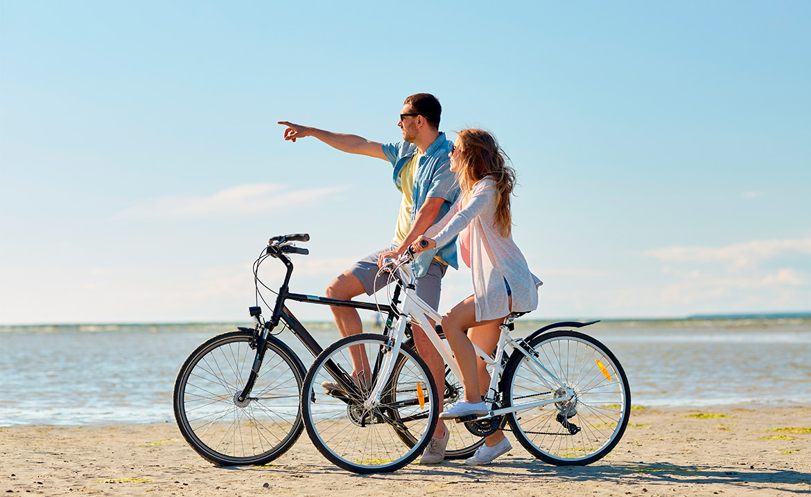 couple at beach bicycling