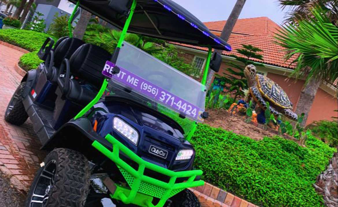 Paradise Fun Rentals: green and black golf cart is stationary in front of a residential home, surrounded by greenery.