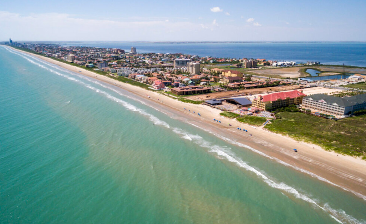 Aerial view of South Padre Island, showcasing the beach and ocean, with bike trails visible along the coastline.
