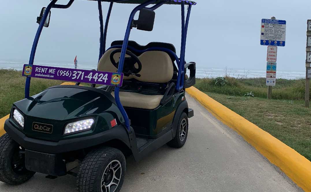 A parked golf cart beside the road, highlighting choices for golf cart sizes for your South Padre vacation.