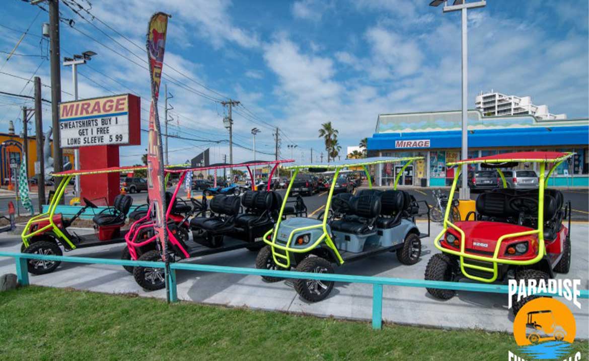 Four golf carts lined up in front of a Paradise Fun Rentals store, showcasing choices for selecting the ideal cart size for your South Padre visit.