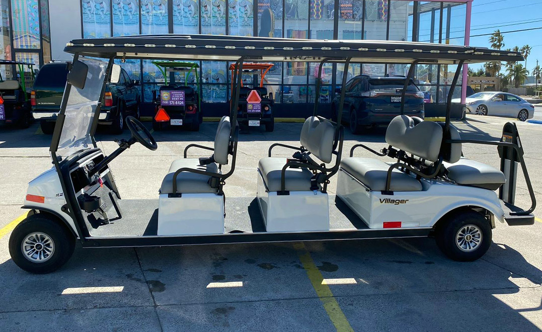A white golf cart featuring four seats and a roof, suitable for group travel in South Padre Island.