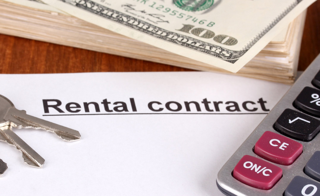 Rental contract with dollars on wooden background close-up