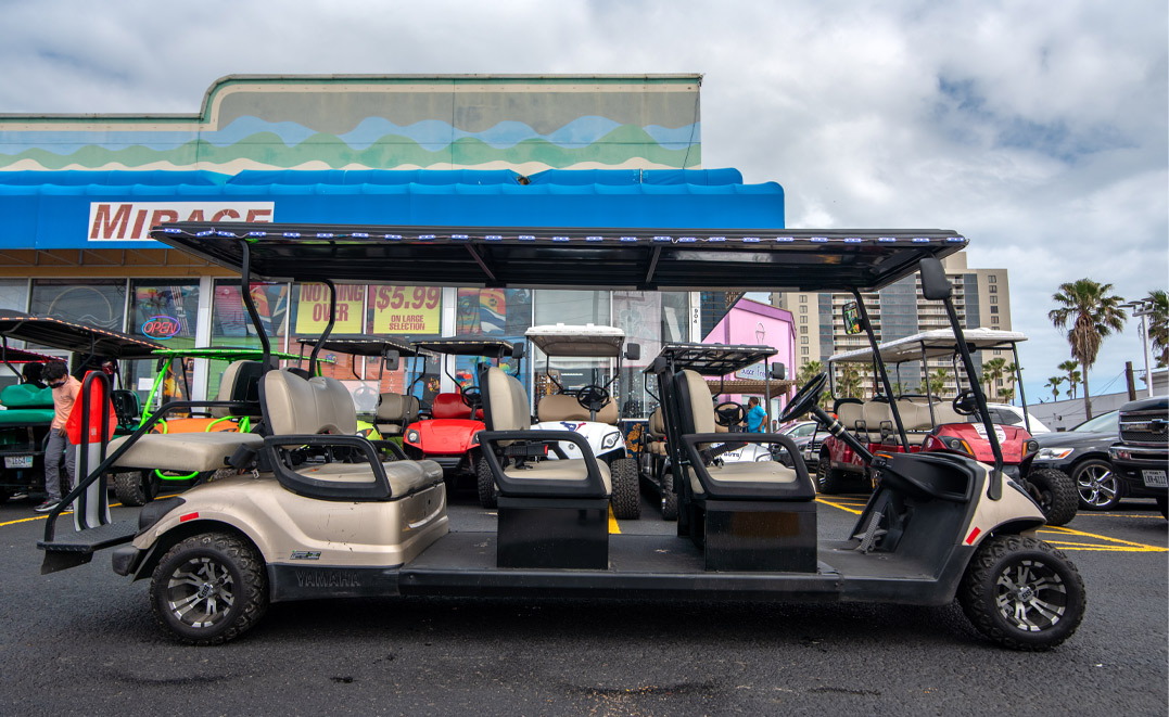 A parked golf cart in front of a store, highlighting its utility and accessibility for shoppers in the area.