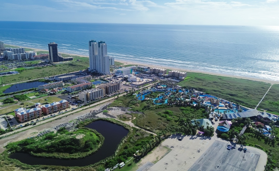 Large waterpark near Isla Blanca Beach in resort town South Padre Island, tropical white sandy beaches with high-rise condos, beach-front hotels, vacation rentals, coastal lagoons, aerial view. USA